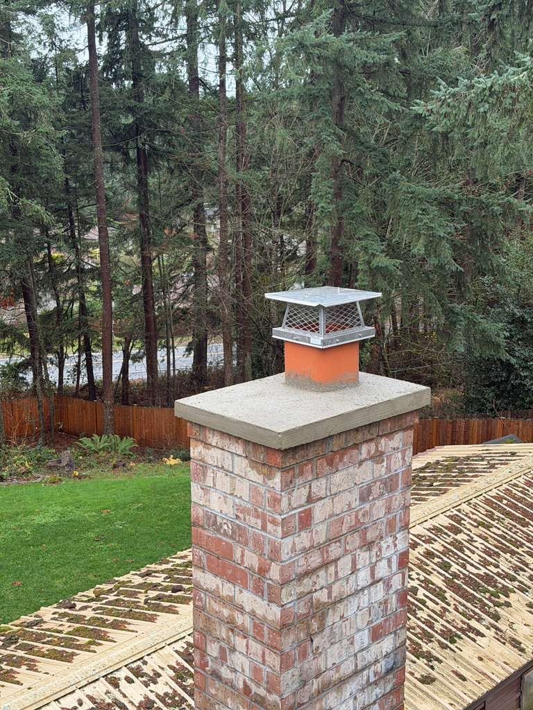 An exterior brick chimney with its cap, on a suburban house