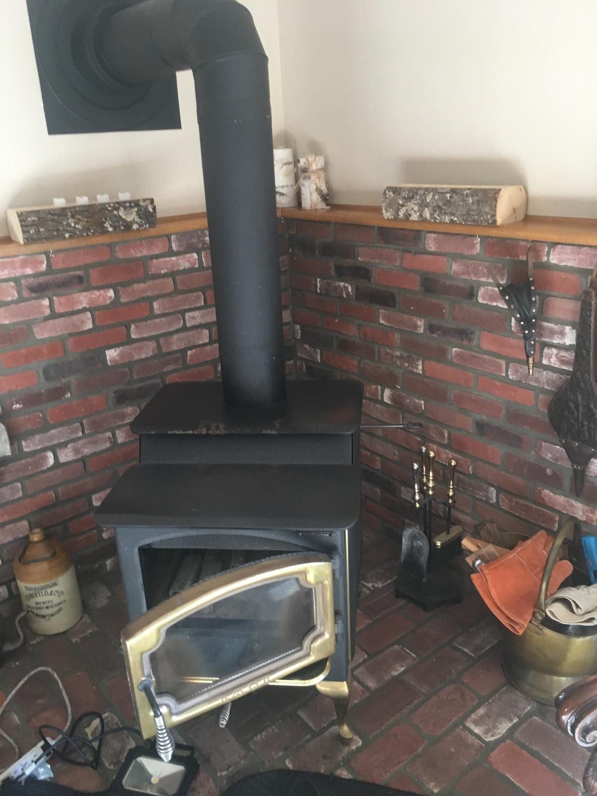 A wood-burning stove set into a brick surround in a New Jersey living room