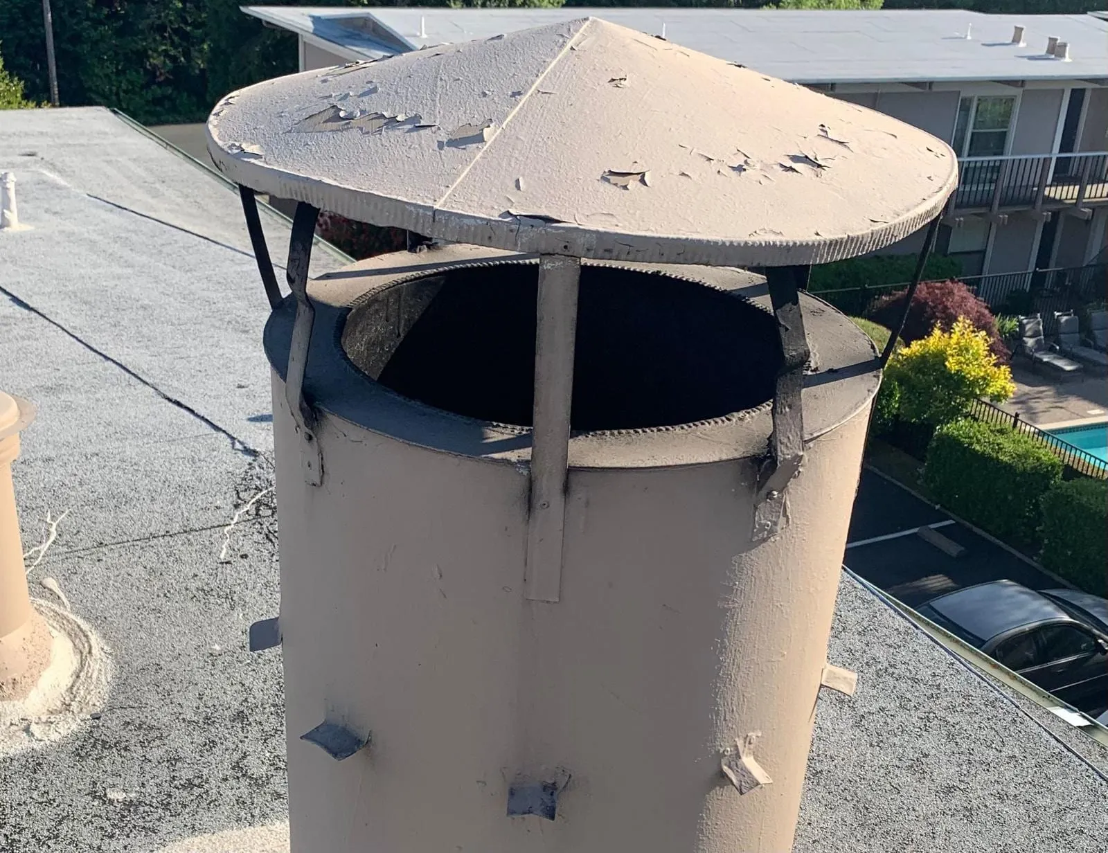 A metal chimney cap and housing on a flat New Jersey roof