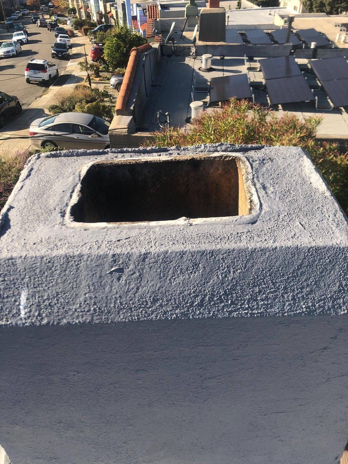 Looking down into an open flue on a flat New Jersey roof during an inspection