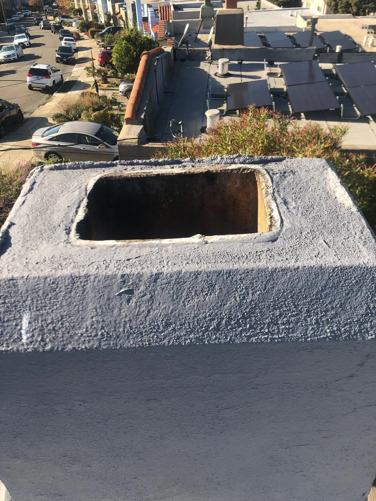 Looking down into an open flue on a flat New Jersey roof during an inspection