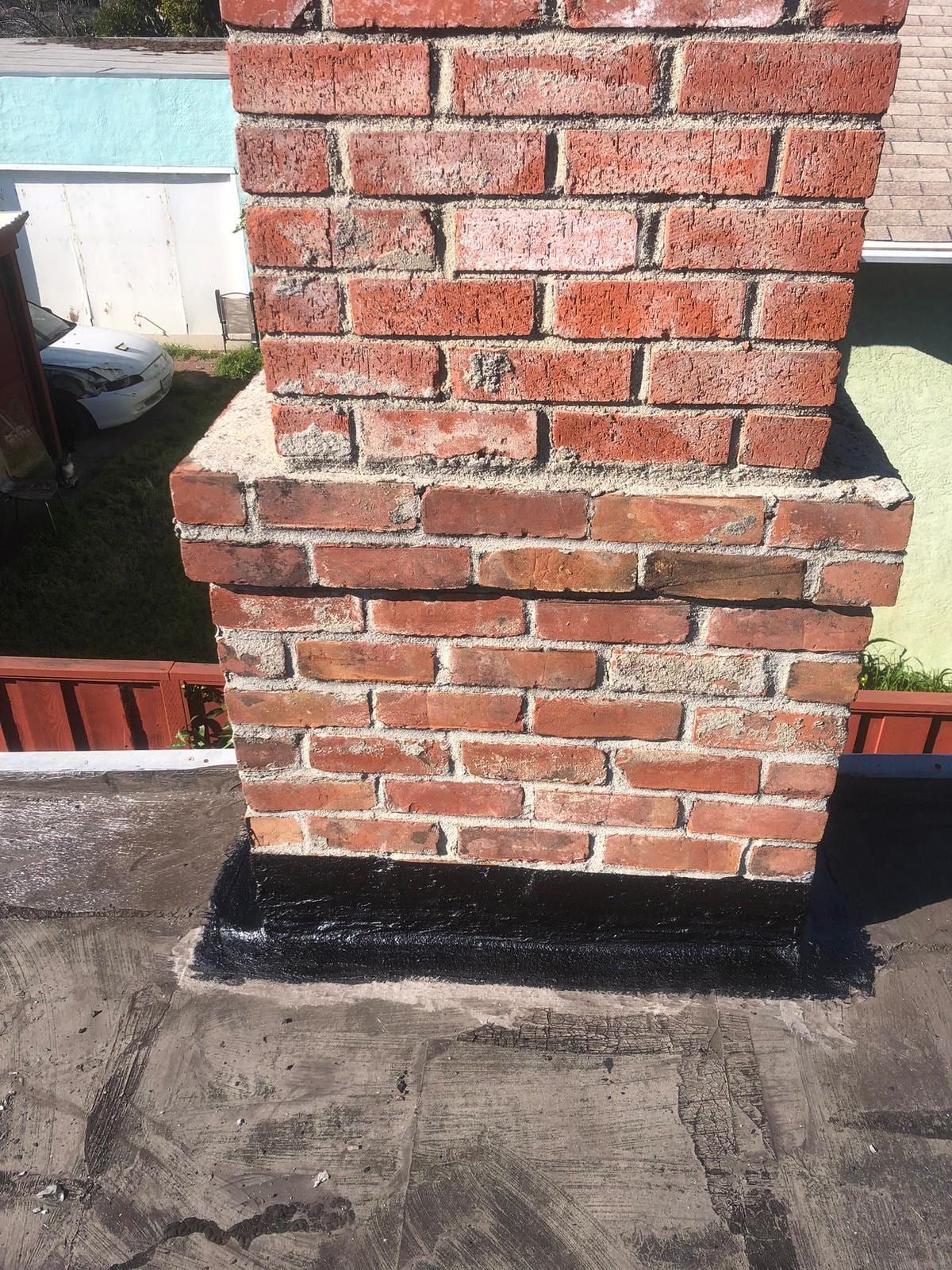 A repointed brick chimney with new flashing on a North Jersey roof