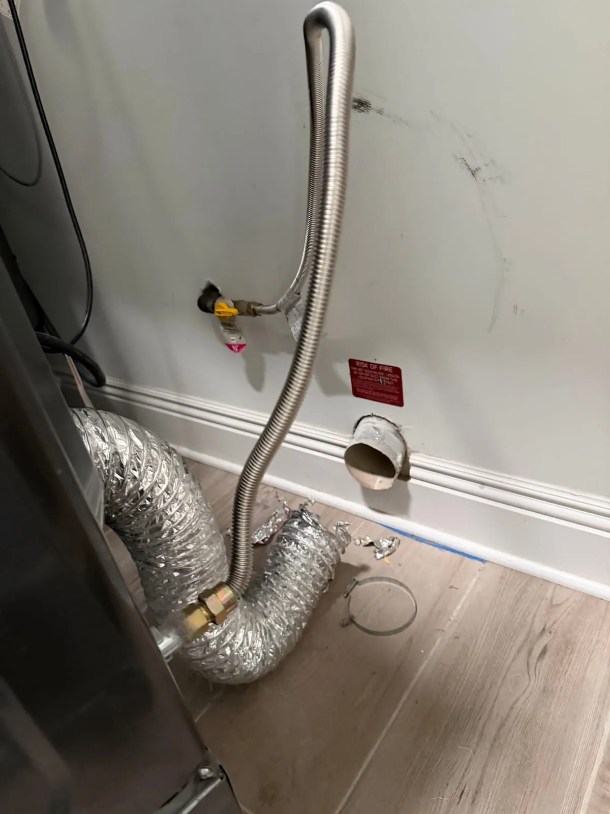 Flexible dryer ducting connected behind a machine in a laundry room